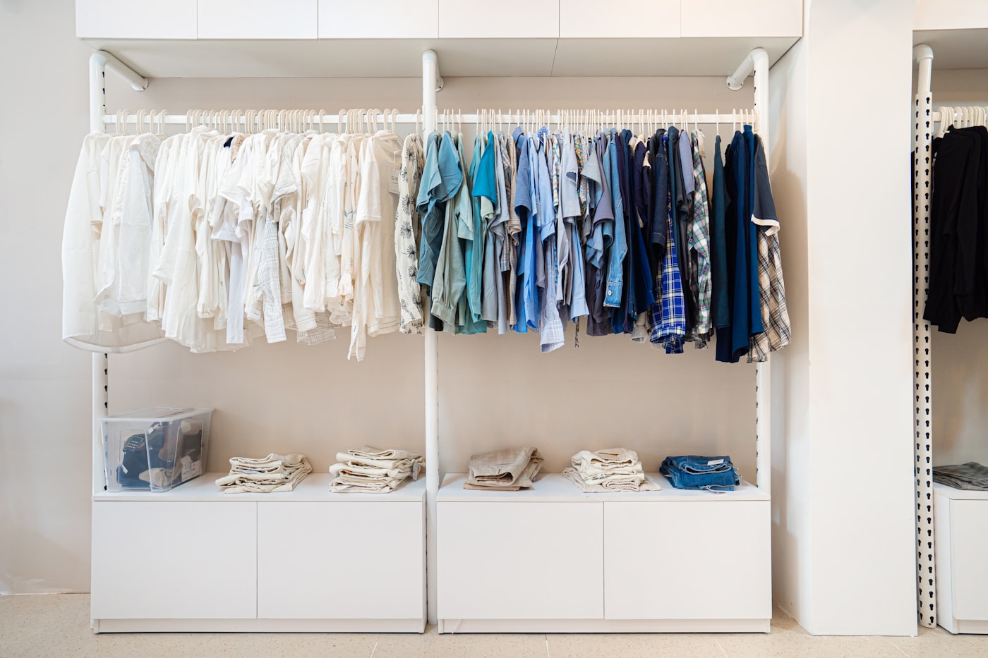 Bright, organized guest closet with matching hangers, folded linens, and clear storage bins